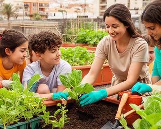 Jóvenes aprendiendo a plantar verduras junto a una monitora en un huerto urbano del sur de Tenerife